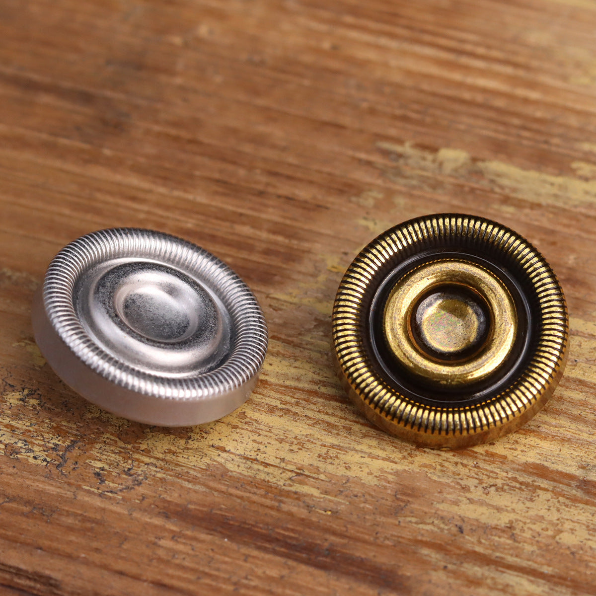 23-mm Metallknöpfe antikgold und silber, zwei Vorderseiten auf Holz