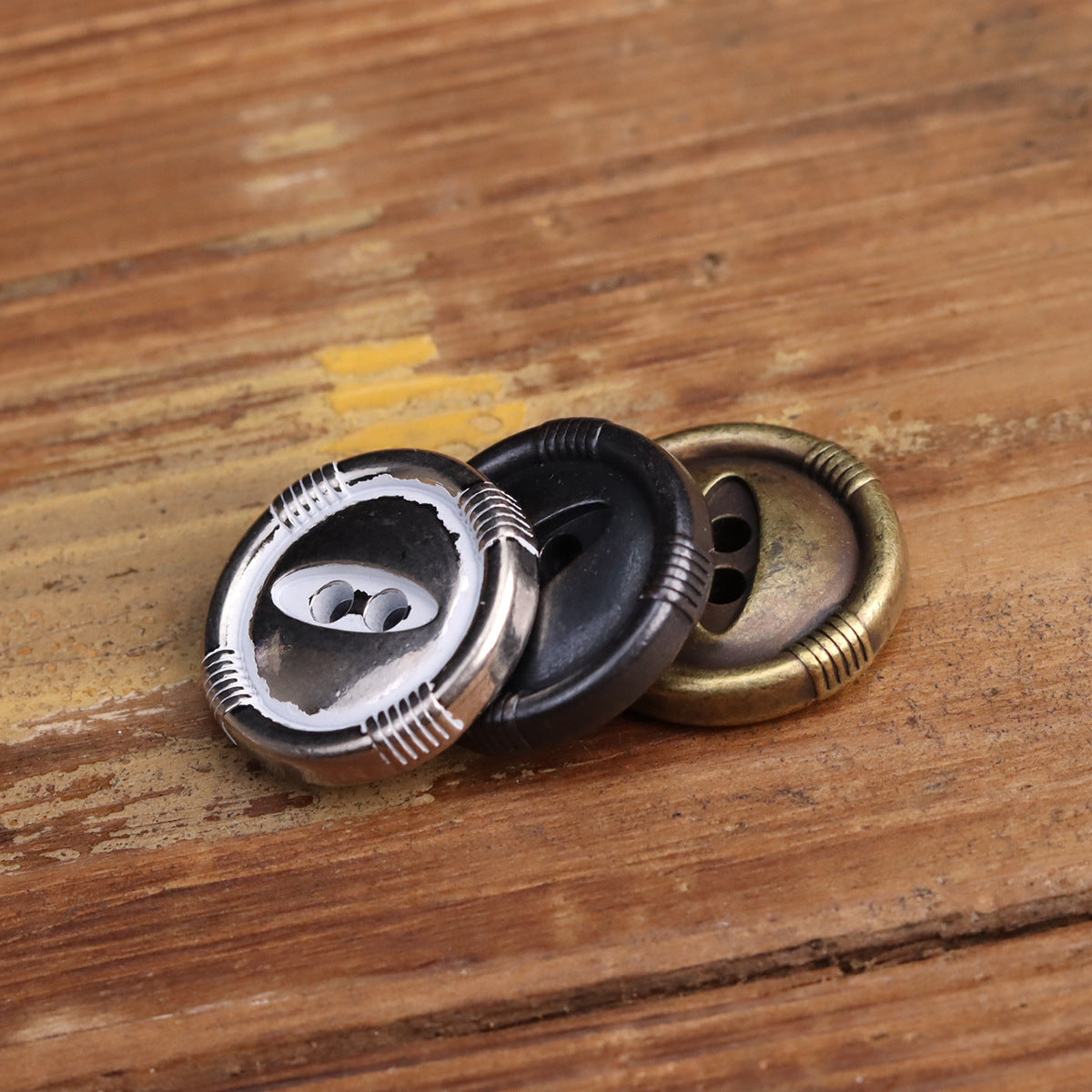 Fish-eye metal buttons in silver, black and bronze, two-hole faces with ridged outer band