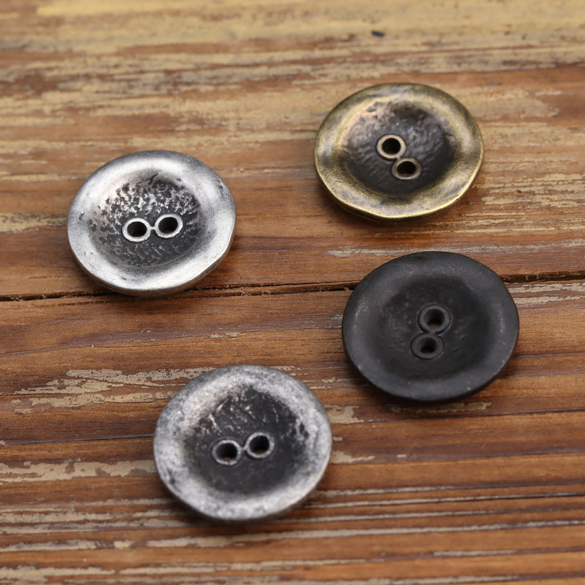 Antiqued two-hole jacket buttons in silver, black silver, and bronze tones
