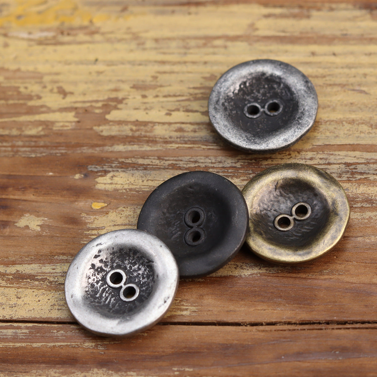 Two-hole metal jacket buttons in antiqued white silver, black silver, and bronze