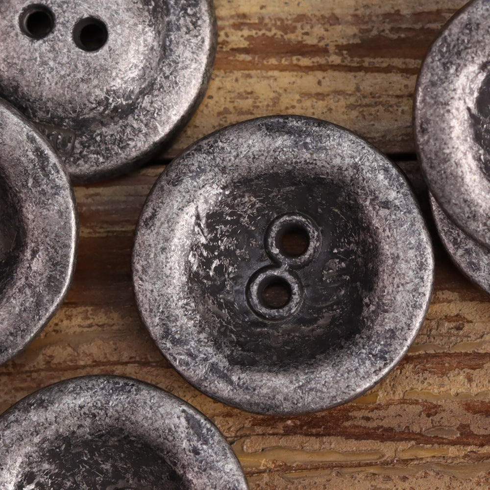 Two-hole metal button with antiqued dark silver sheen, round jacket button