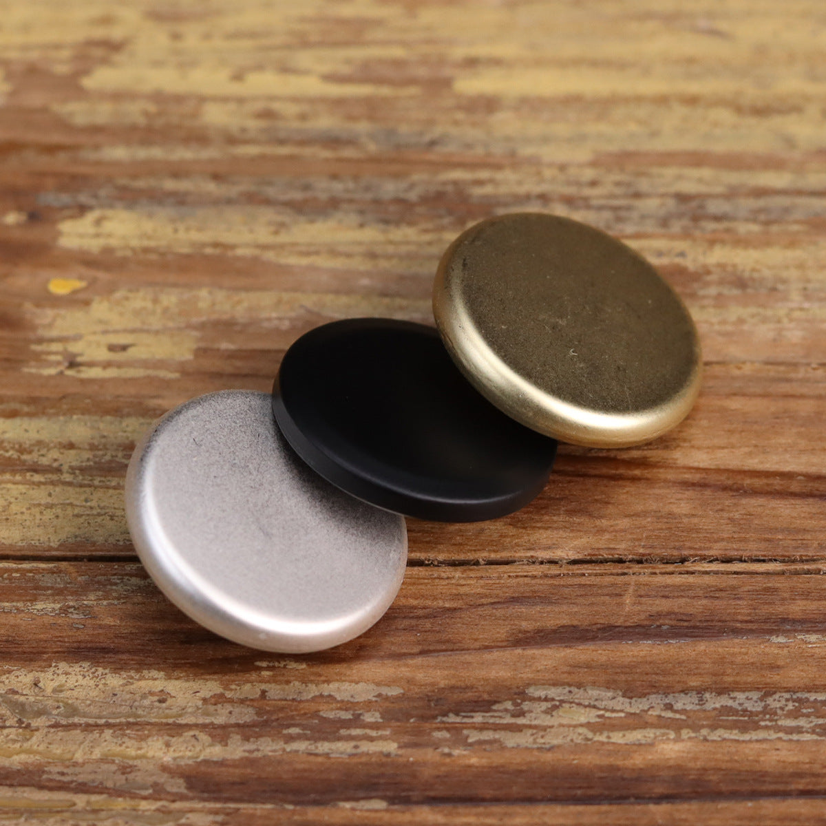 Matte flat-shank metal buttons, overlapping angles in black, silver, and gold