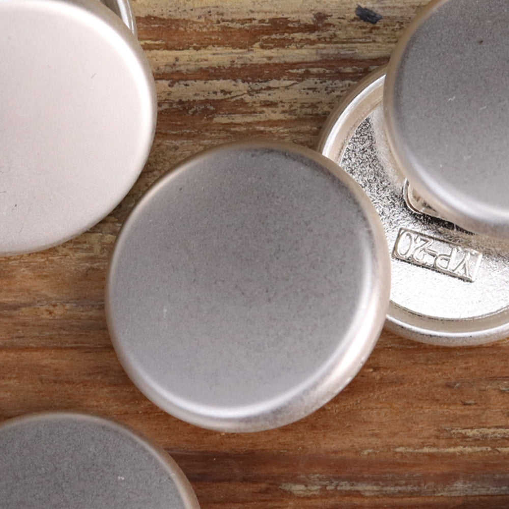 Matte flat-shank metal buttons close-up: silver round front faces