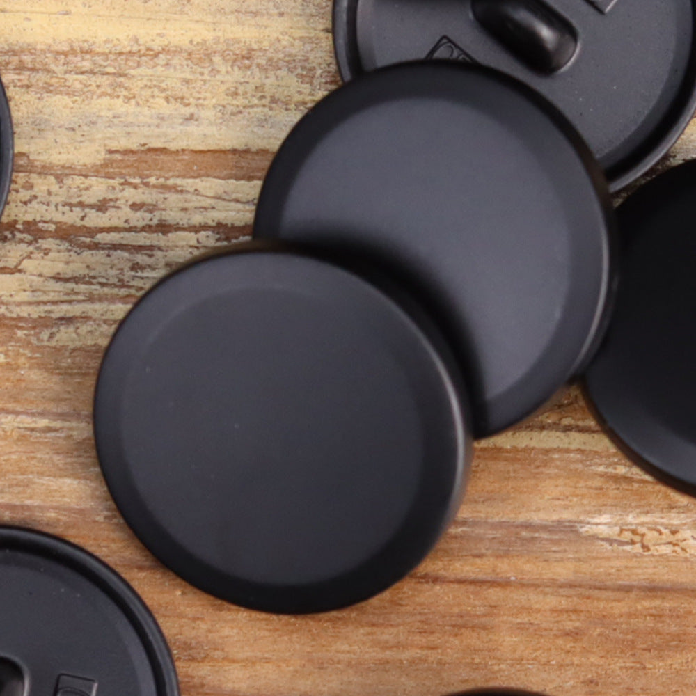 Matte flat-shank metal buttons, close-up of black round front faces