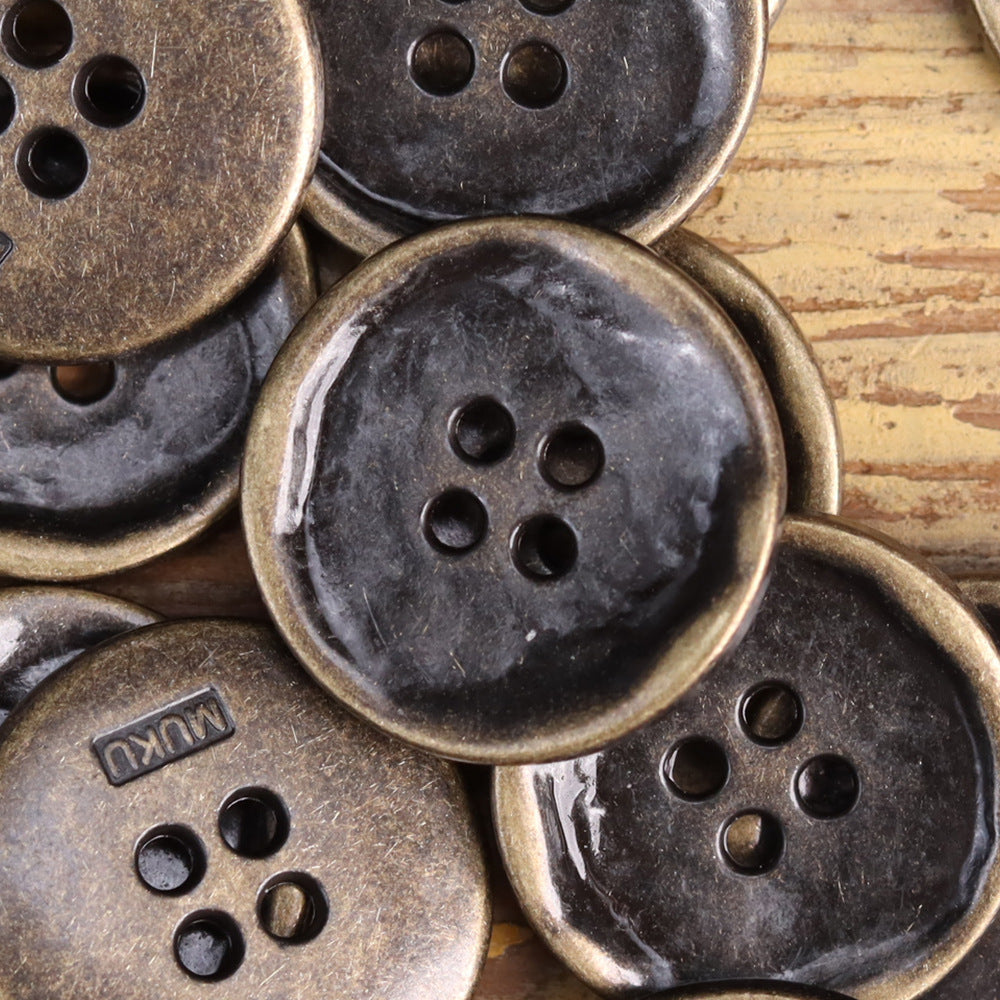 Close-up of 4-hole jacket buttons in antique bronze, antique silver, and black