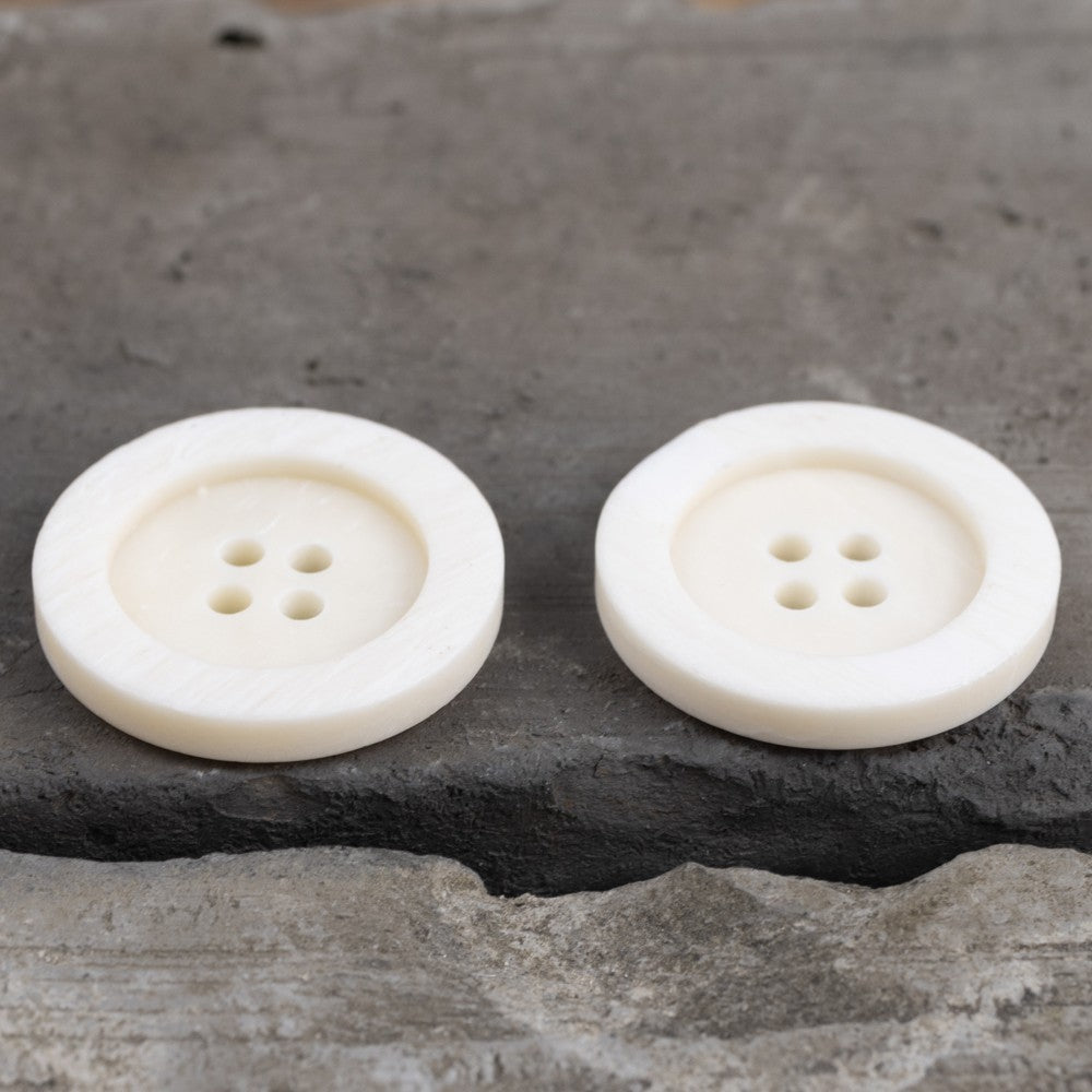 Off-white wide-edged button pair with 4 holes and recessed front