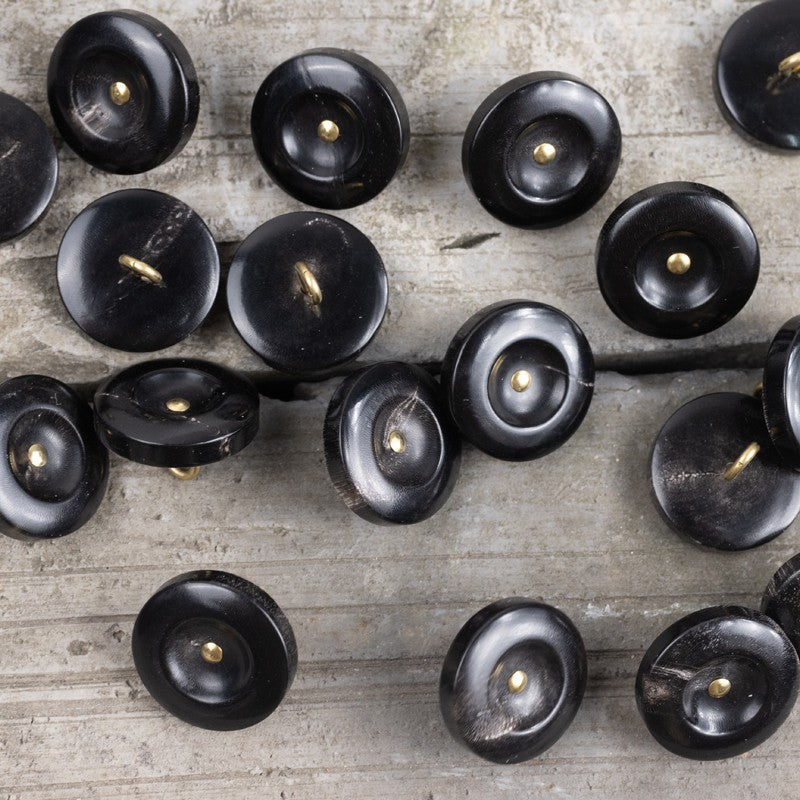 Pack of black horn shank buttons, wide-edged discs with brass posts