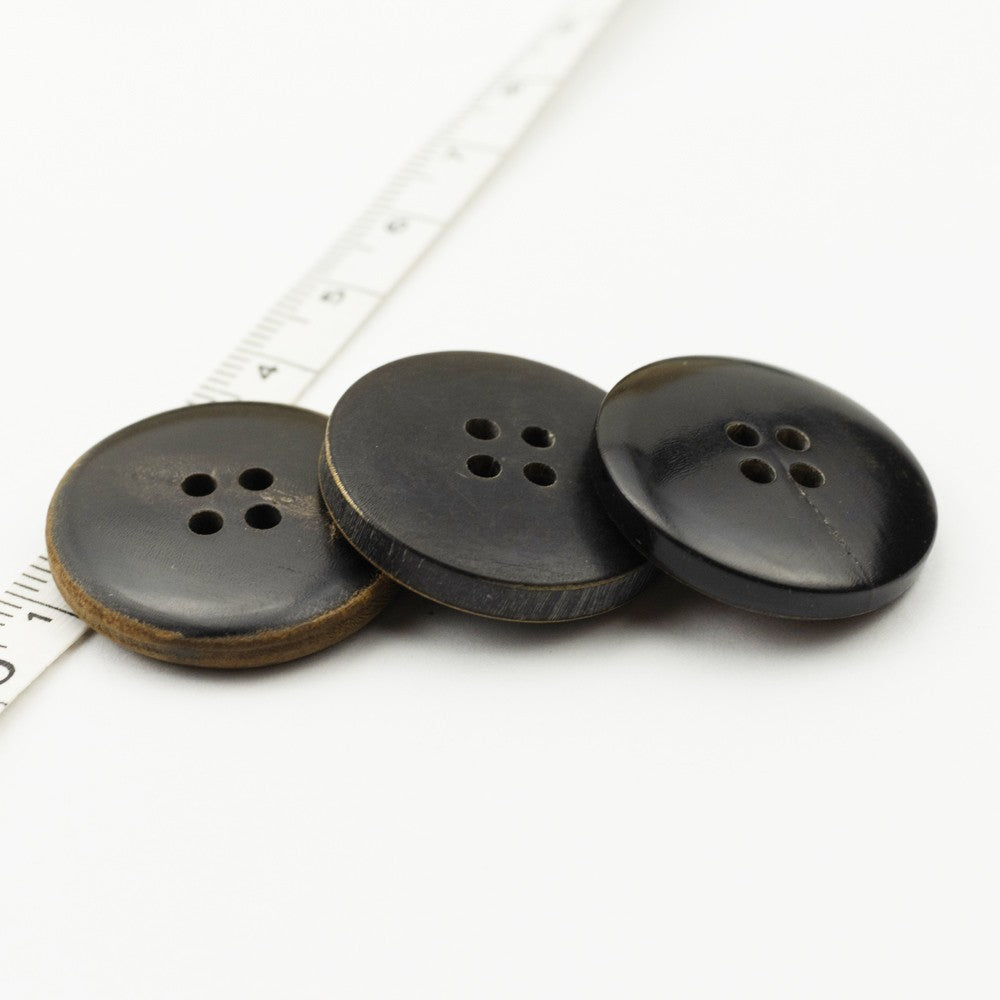 Set of flat retro horn buttons, dark black with tan rim, four holes each
