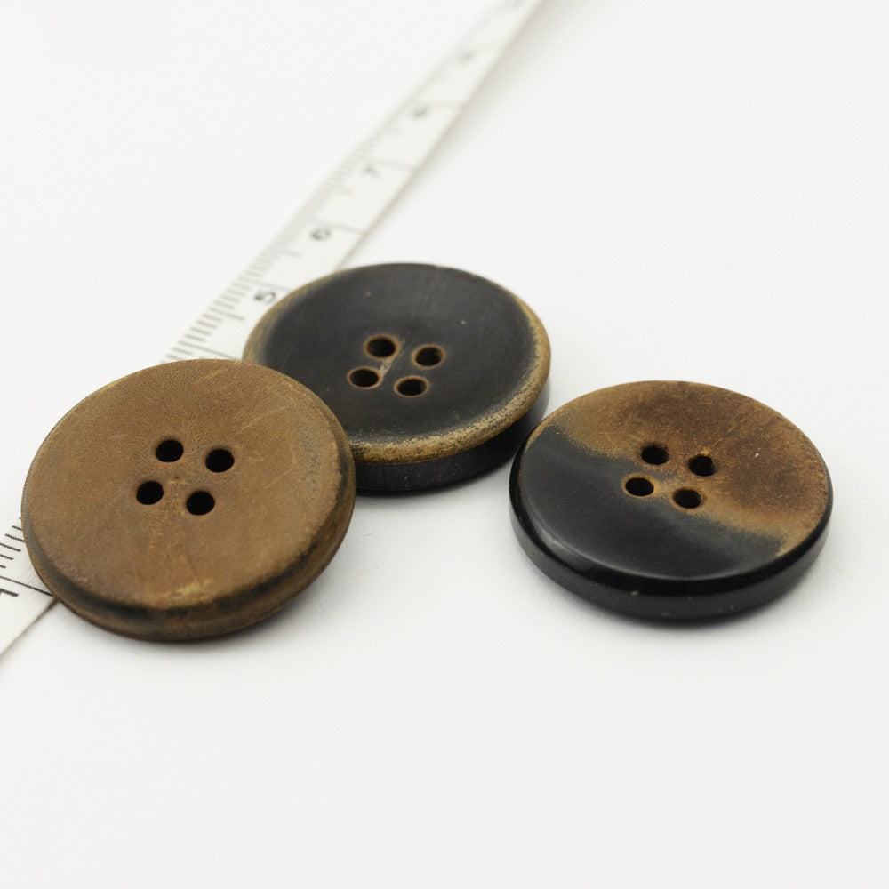 Three flat retro horn buttons in black and dark brown tones, four-hole design, front