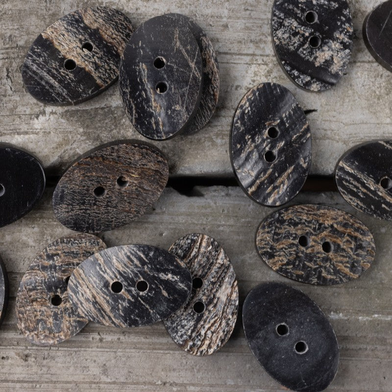 Mixed black horn buttons with two holes, including flower and oval-like shapes
