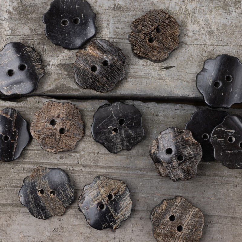 Varied black horn buttons with two holes: flower, oval, and square shapes