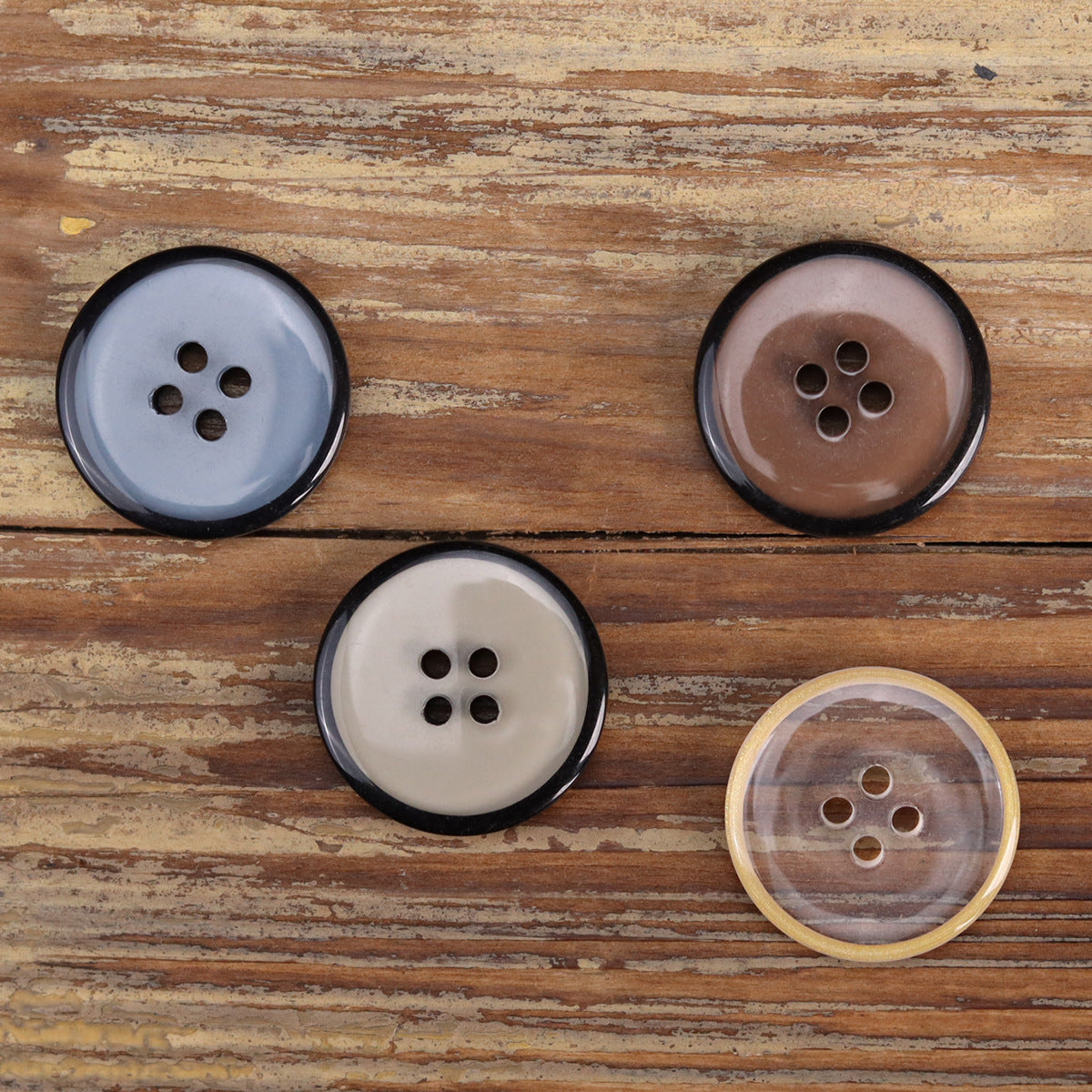 Four-hole transparent resin jacket buttons, blue, brown, and white with dark rims