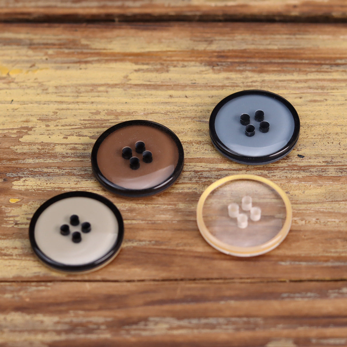 Four-hole transparent resin jacket buttons in clear, white, and dark brown shades