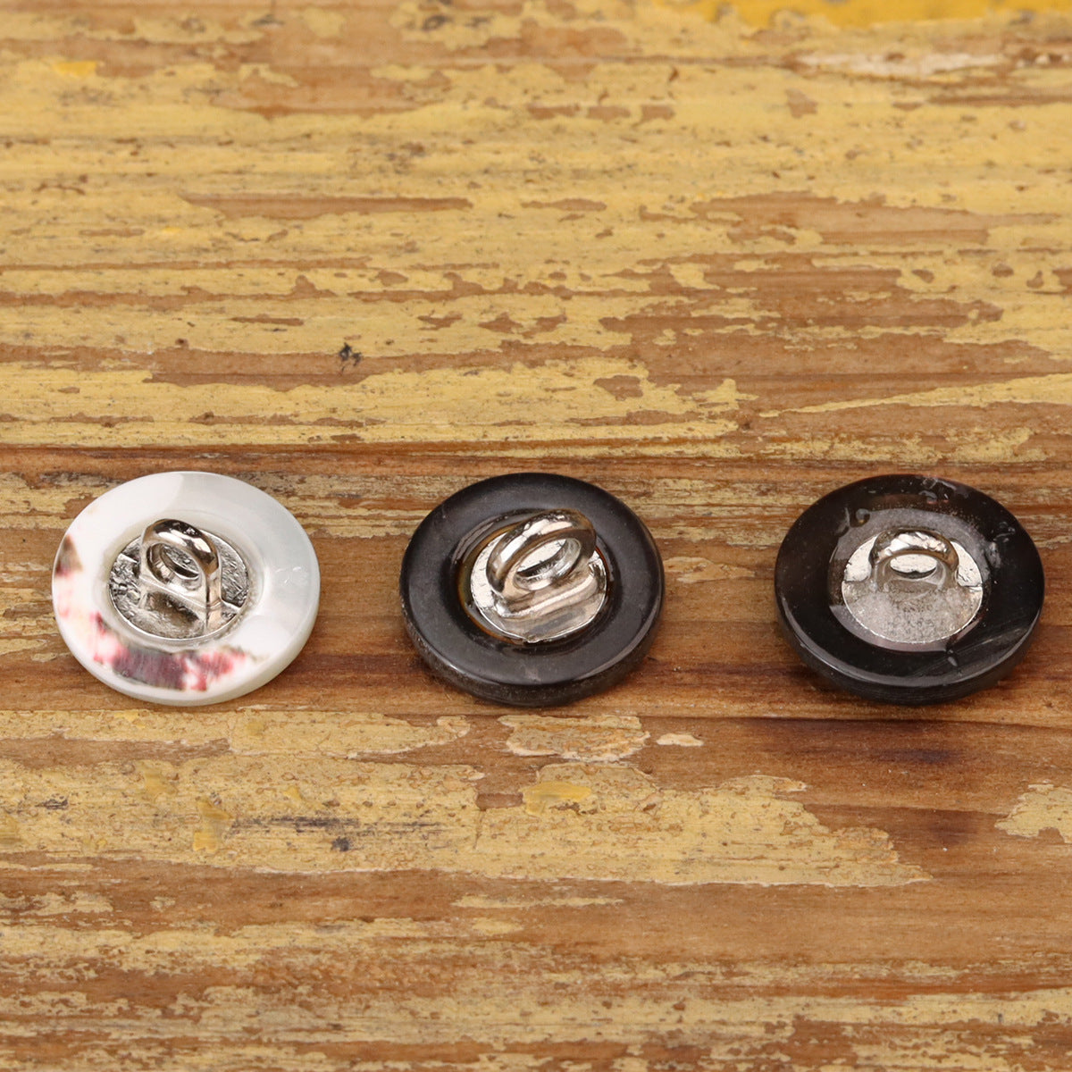 18L flat sewing buttons (3 colors) showing metal feet underside: white, dark, and iridescent