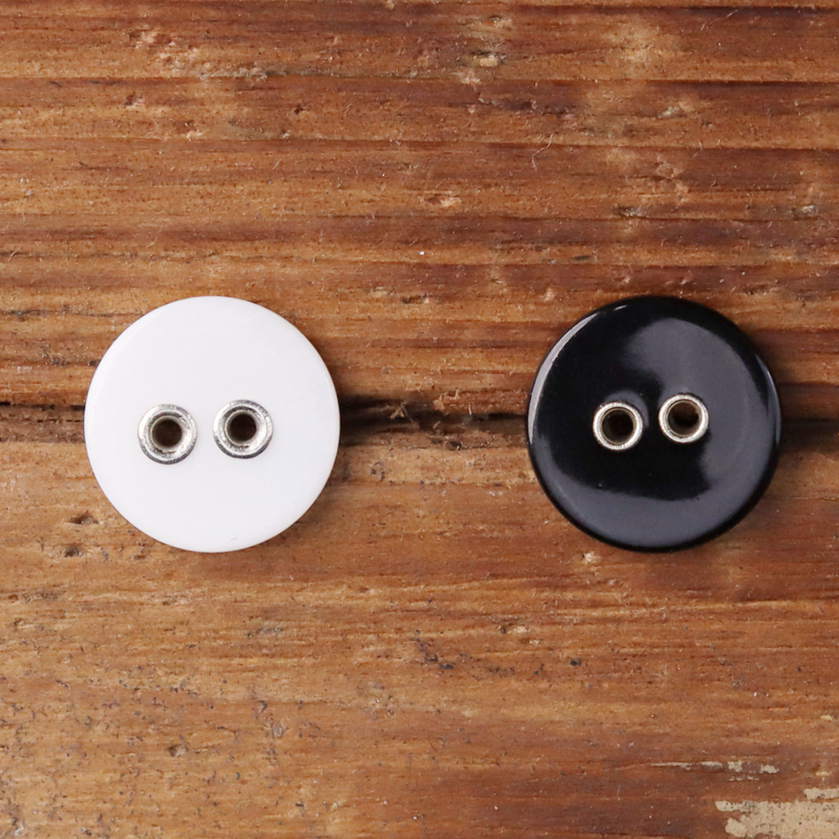 2-hole metal shell buttons, white and black, showing metal loop backs