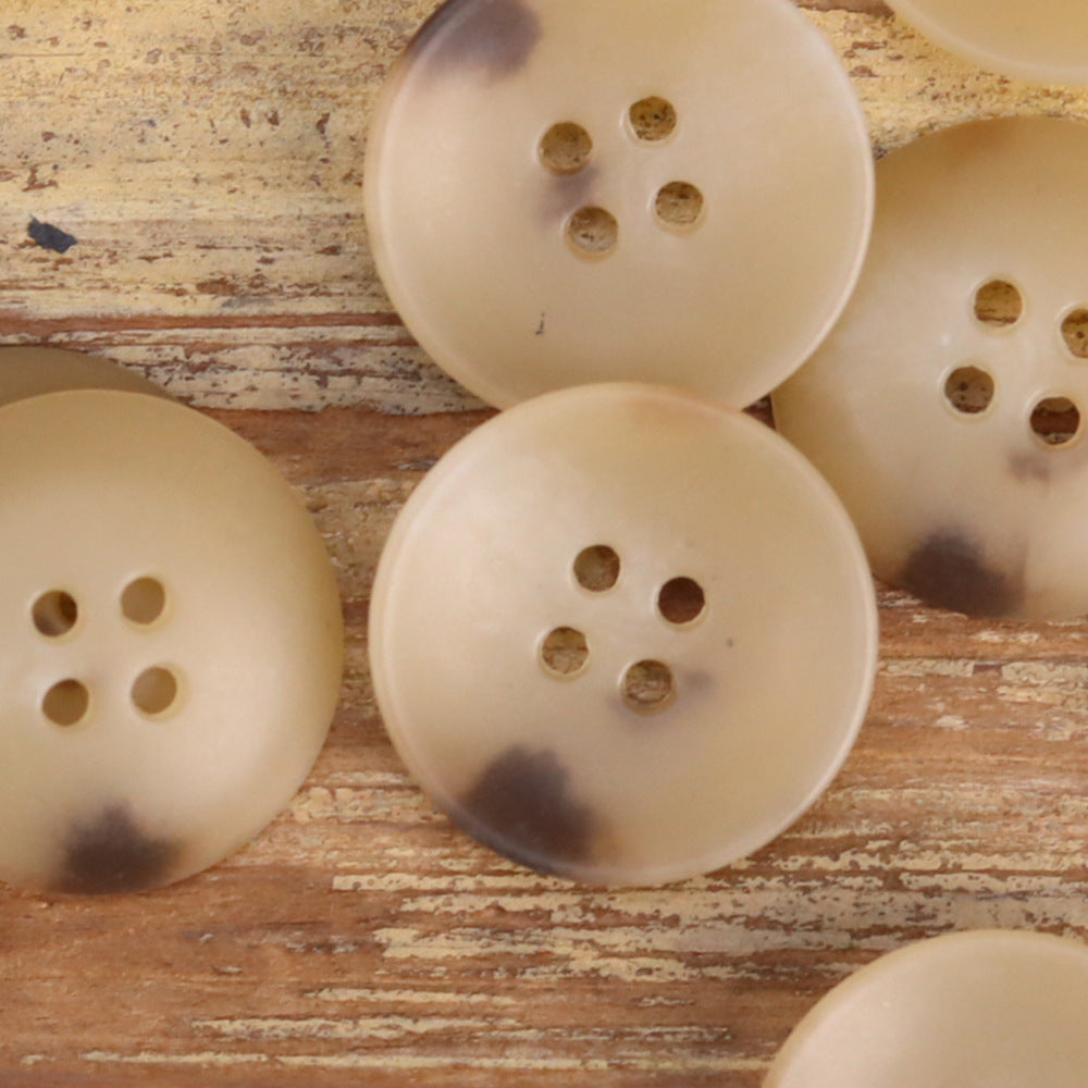 Cream/beige 4-hole buttons with bowl shape and subtle mottling, close-up