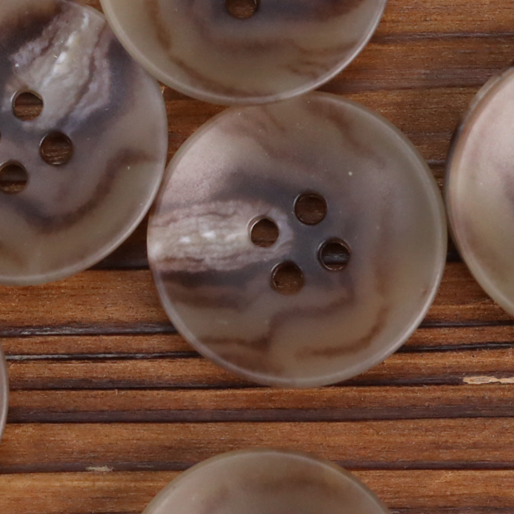 Beige/cream 4-hole buttons with bowl shape and marble-like pattern, close-up