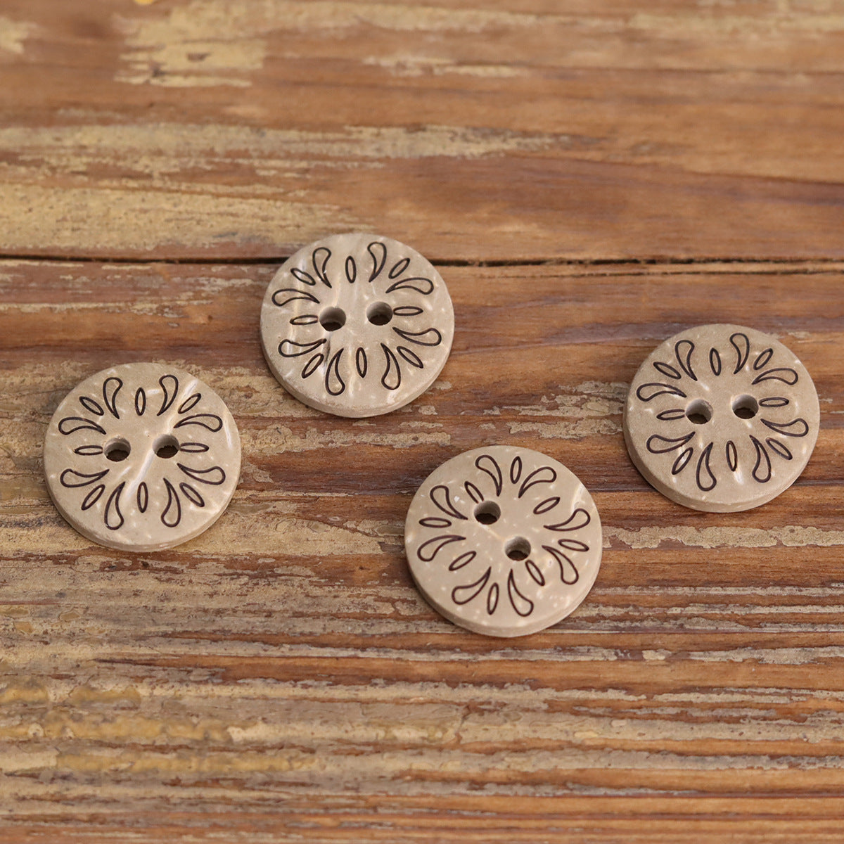 2-hole wooden buttons with stamped floral rosettes, light gray-brown finish
