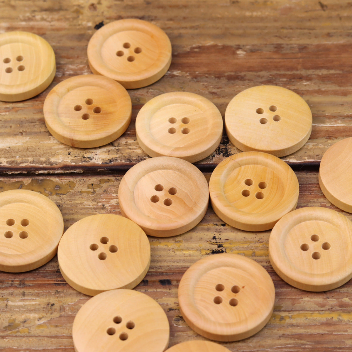 Multiple natural round 4-hole wood buttons, mixed sizes and hole patterns