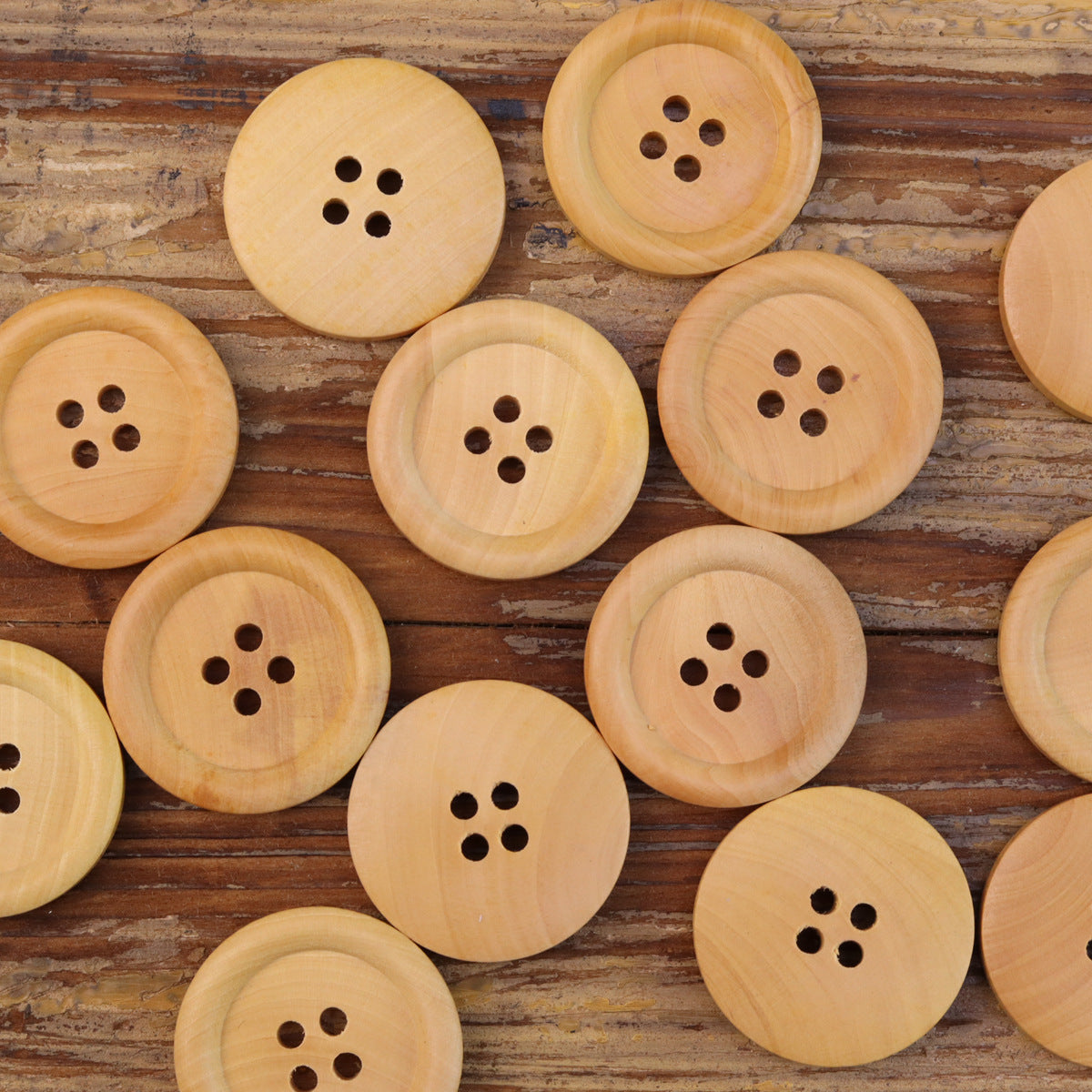 Assorted natural round 4-hole wood buttons, multiple sizes with visible holes