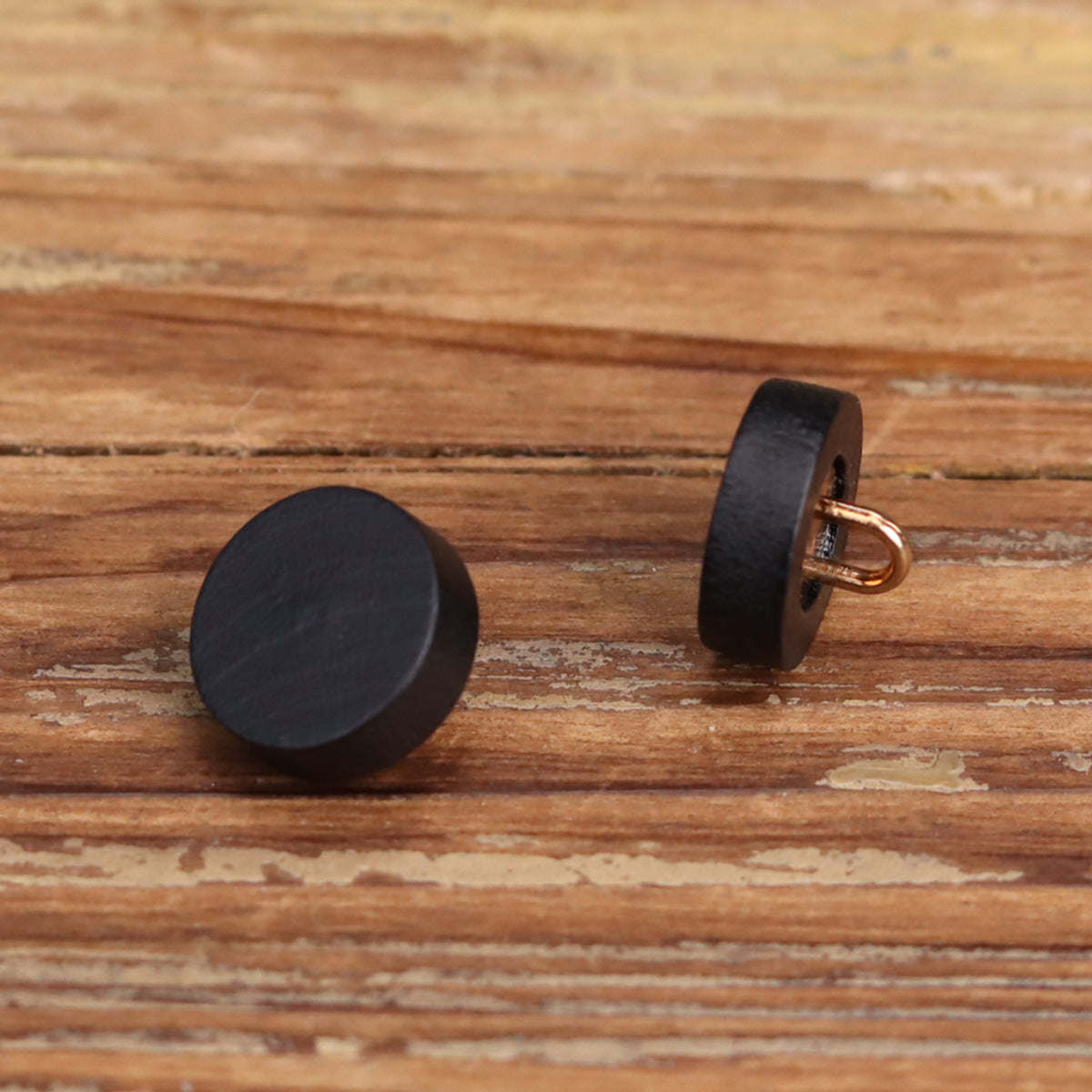 Black flat wooden buttons with metal shank on the side, single pair view