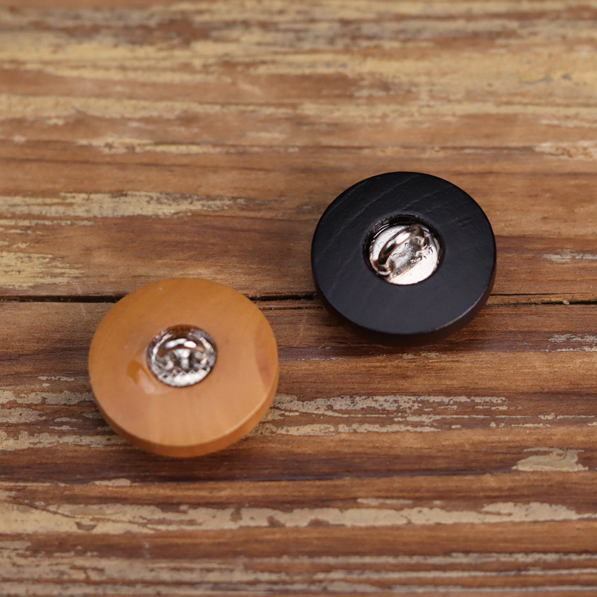 Light tan and dark wooden buttons with metal shank showing
