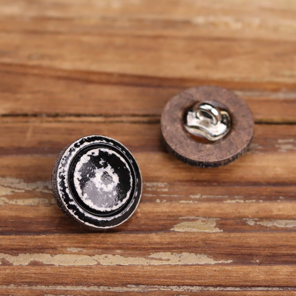 Set of round lacquered wooden buttons showing metal shank backs; distressed black top