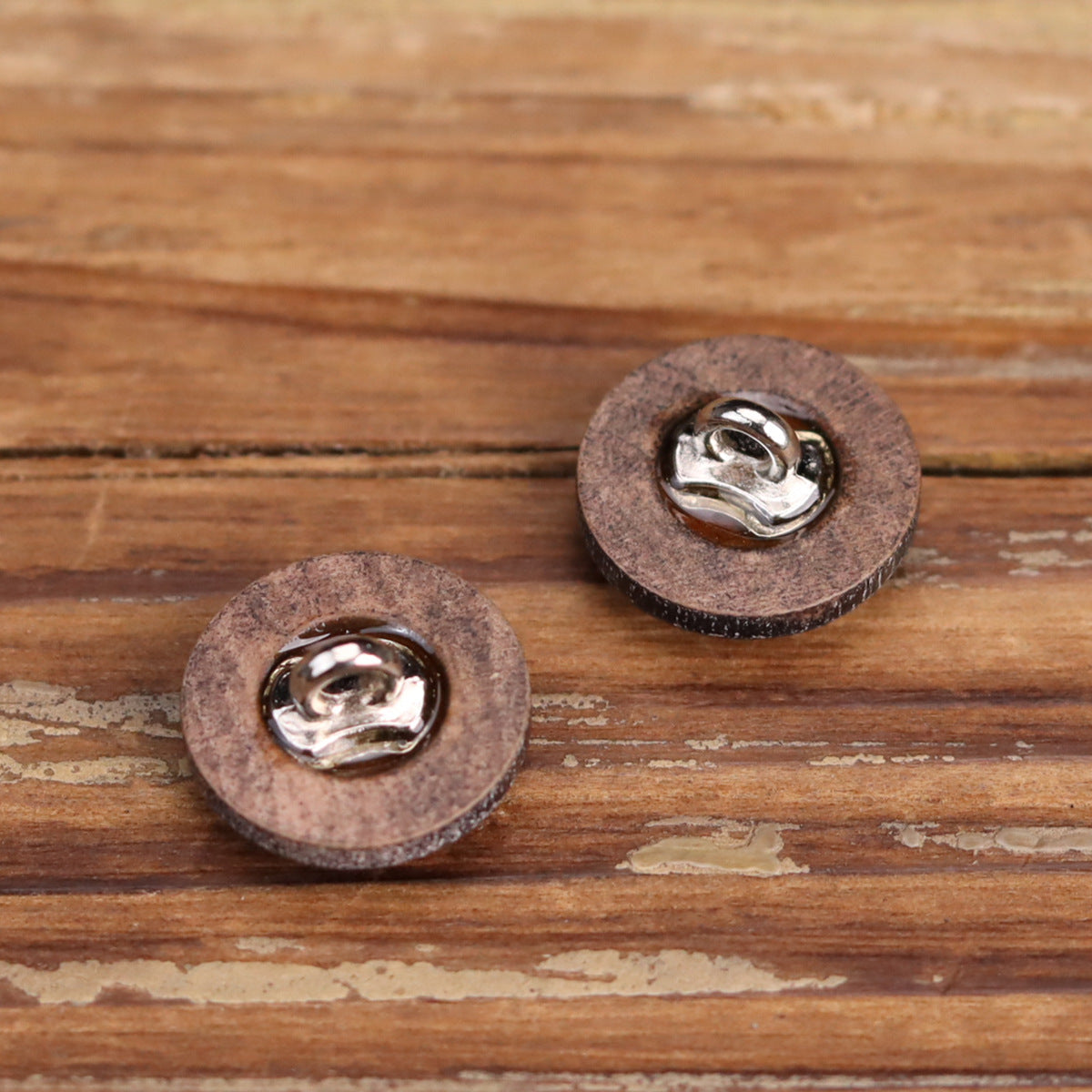 Back view of distressed round wooden buttons with silver-tone metal shank