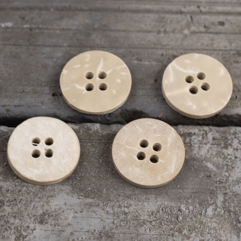 Set of round off-white four-hole flat buttons, worn vintage finish