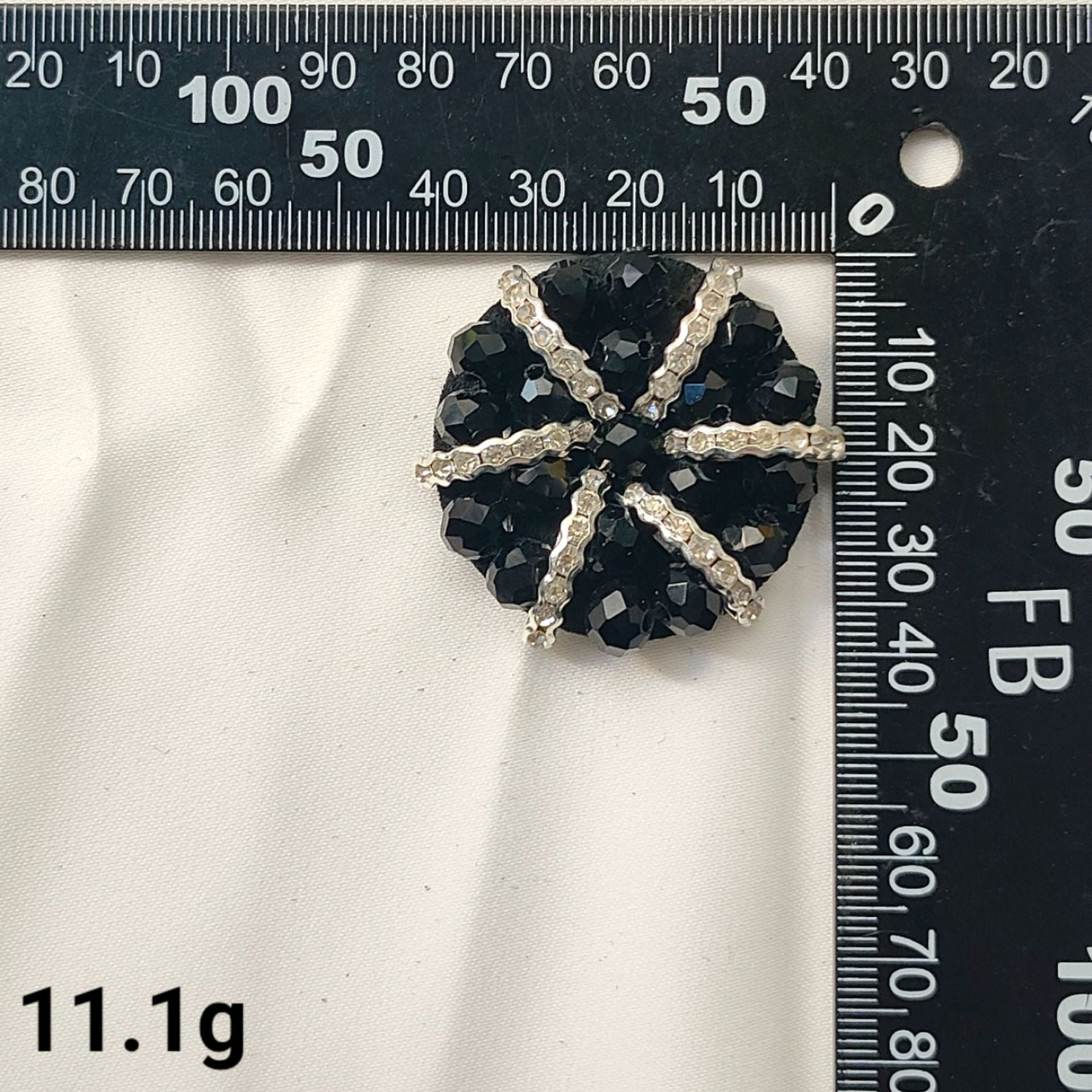 Black star-shaped rhinestone patch with gold-tone edging and dark facets