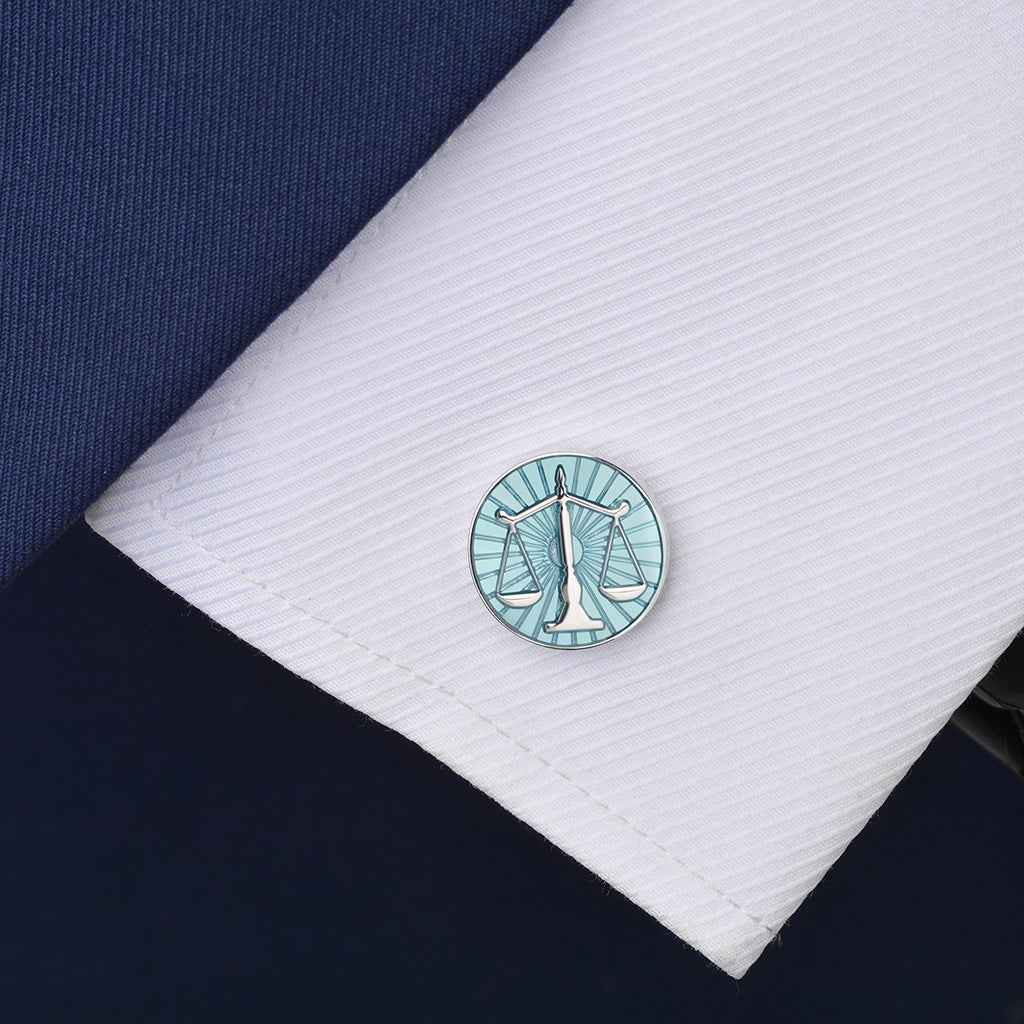 Round blue balance scale cufflinks on white shirt cuff; silver-tone back