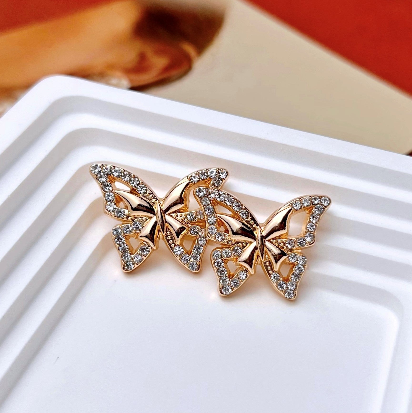 Butterfly rhinestone metal shank button on tray, gold-tone with cutout wings