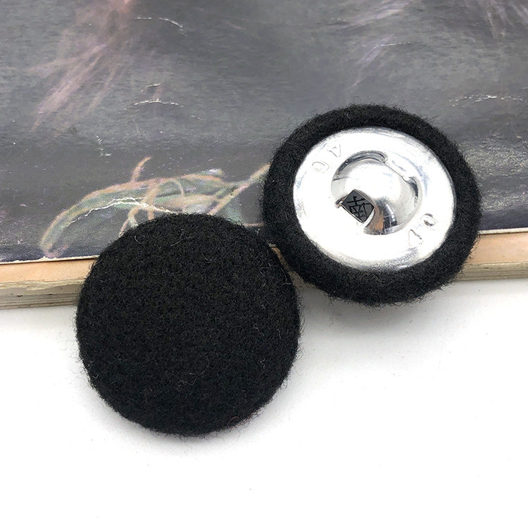 Two 28mm fabric-covered buttons: black textile face with silver metal snap