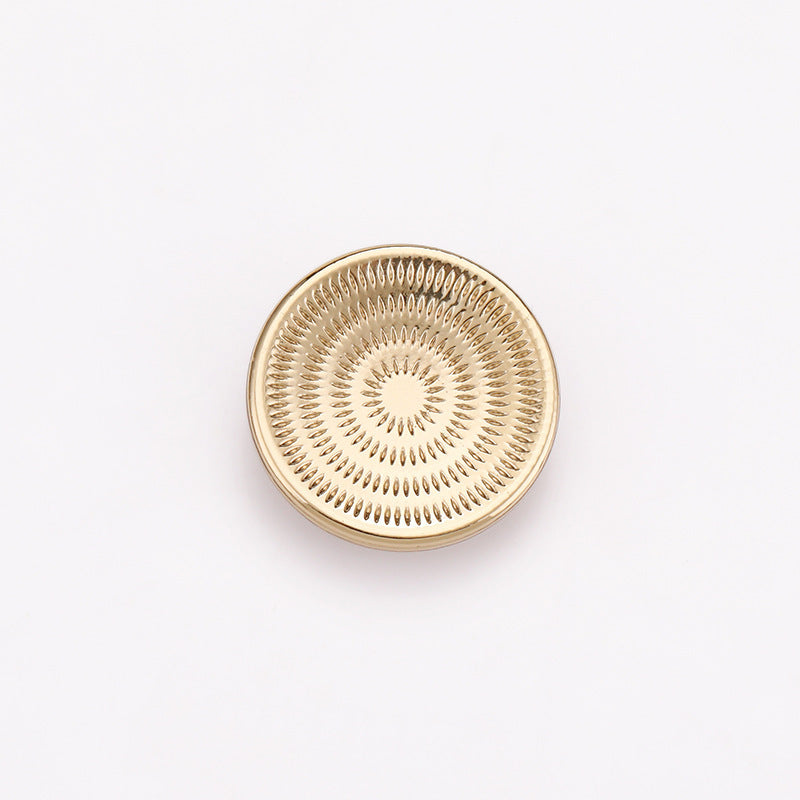 Light gold spiral concave metal shank button with concentric ring texture on face