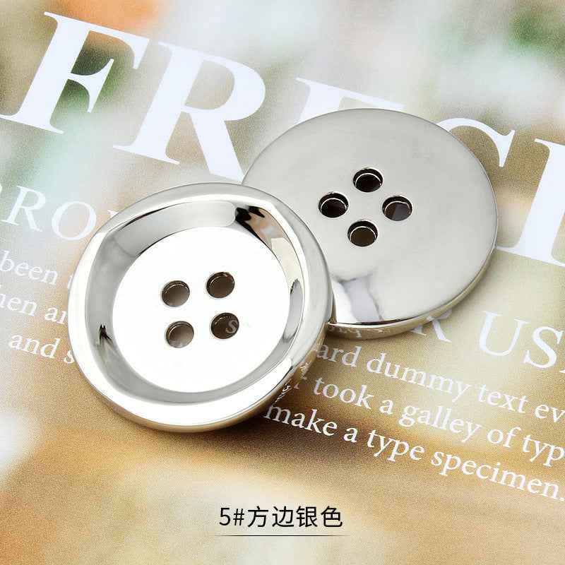 银白色圆形四孔金属纽扣，边缘金属反光，缝制用