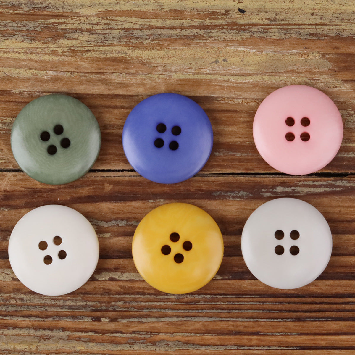 Assorted round 4-hole buttons in green, blue, pink, white, yellow
