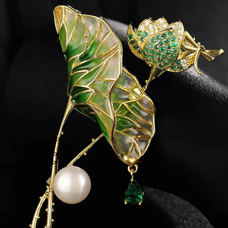 Lotus leaf brooch close-up: emerald-green enamel, zircon accents, white pearl, green drop