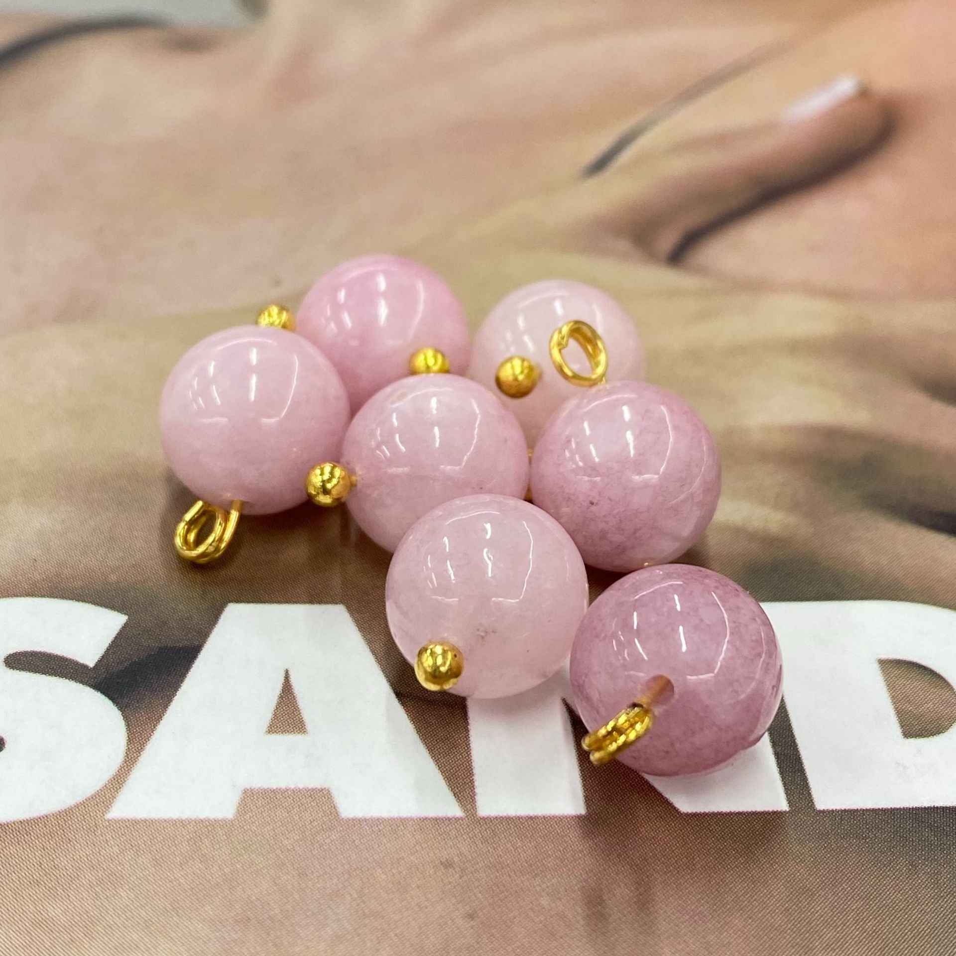 Cluster of pink jade-look ball buttons, gold-tone loop shanks visible