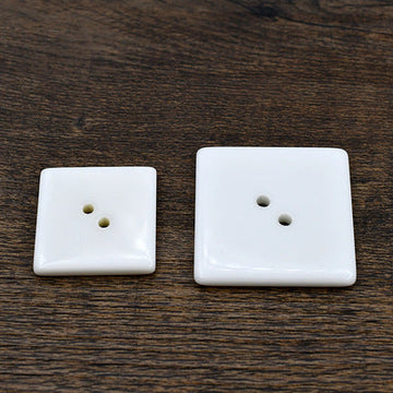 White square two-hole resin buttons, visible front faces