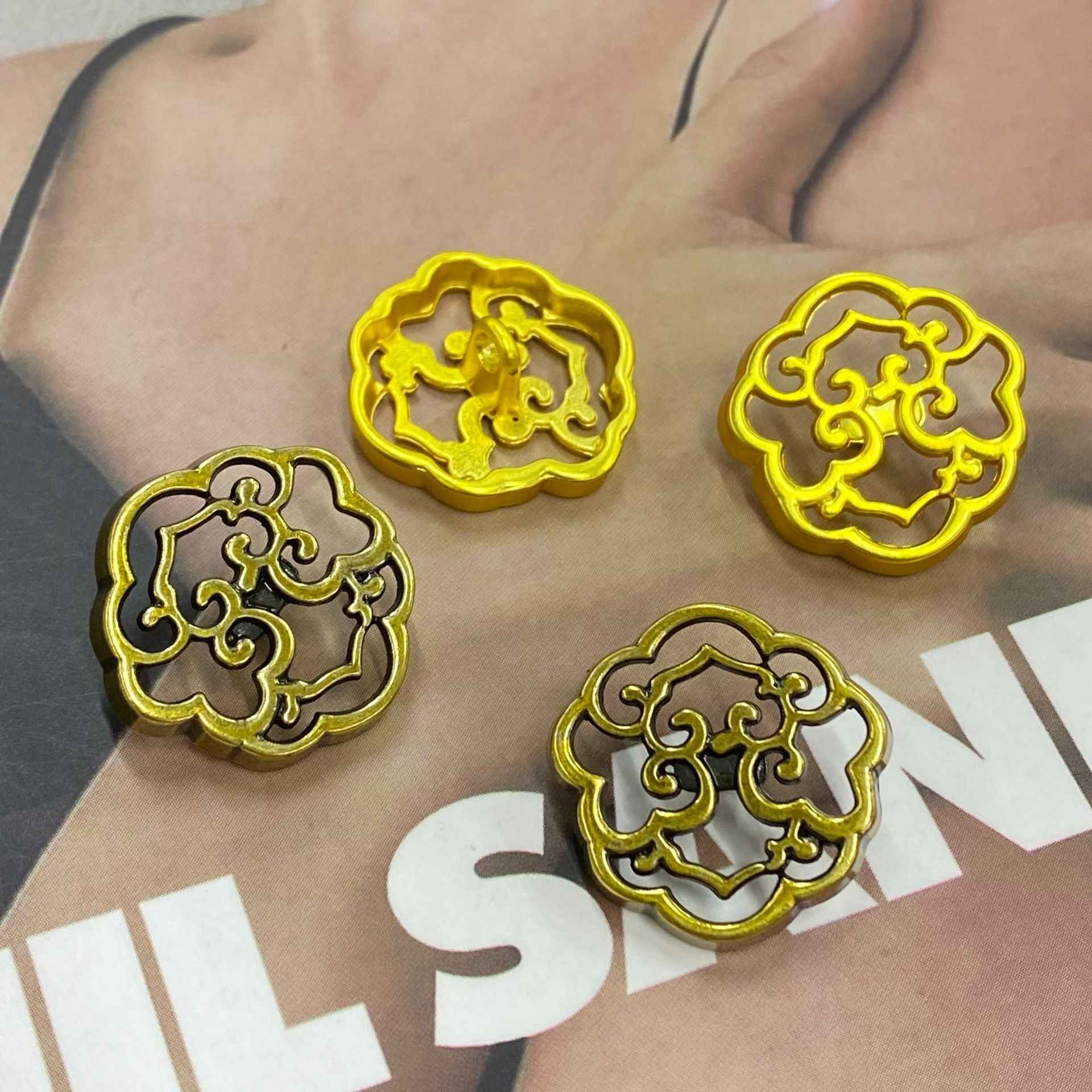 Gold cloud metal shank buttons on fabric, decorative round motif