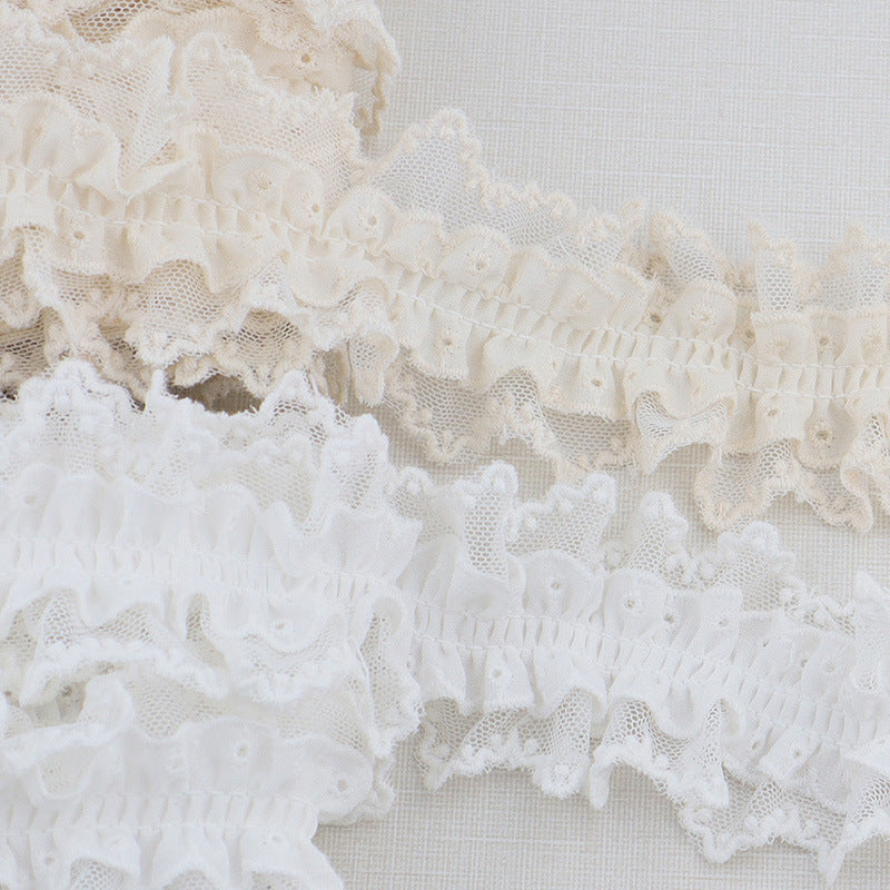 Close view of white double-layer lace ruffle trim with elastic pleats and scallops