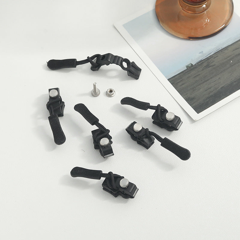 Set of black zipper repair clips with straps and silver metal pins for jackets