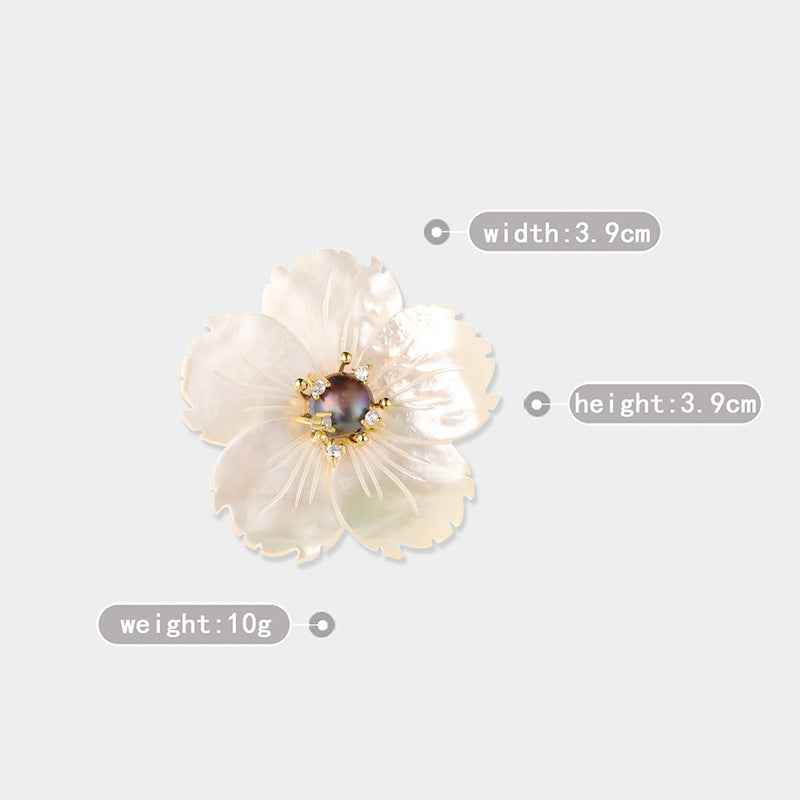 Natural shell flower brooch with dark pearl cabochon and gold-tone rhinestones, front view