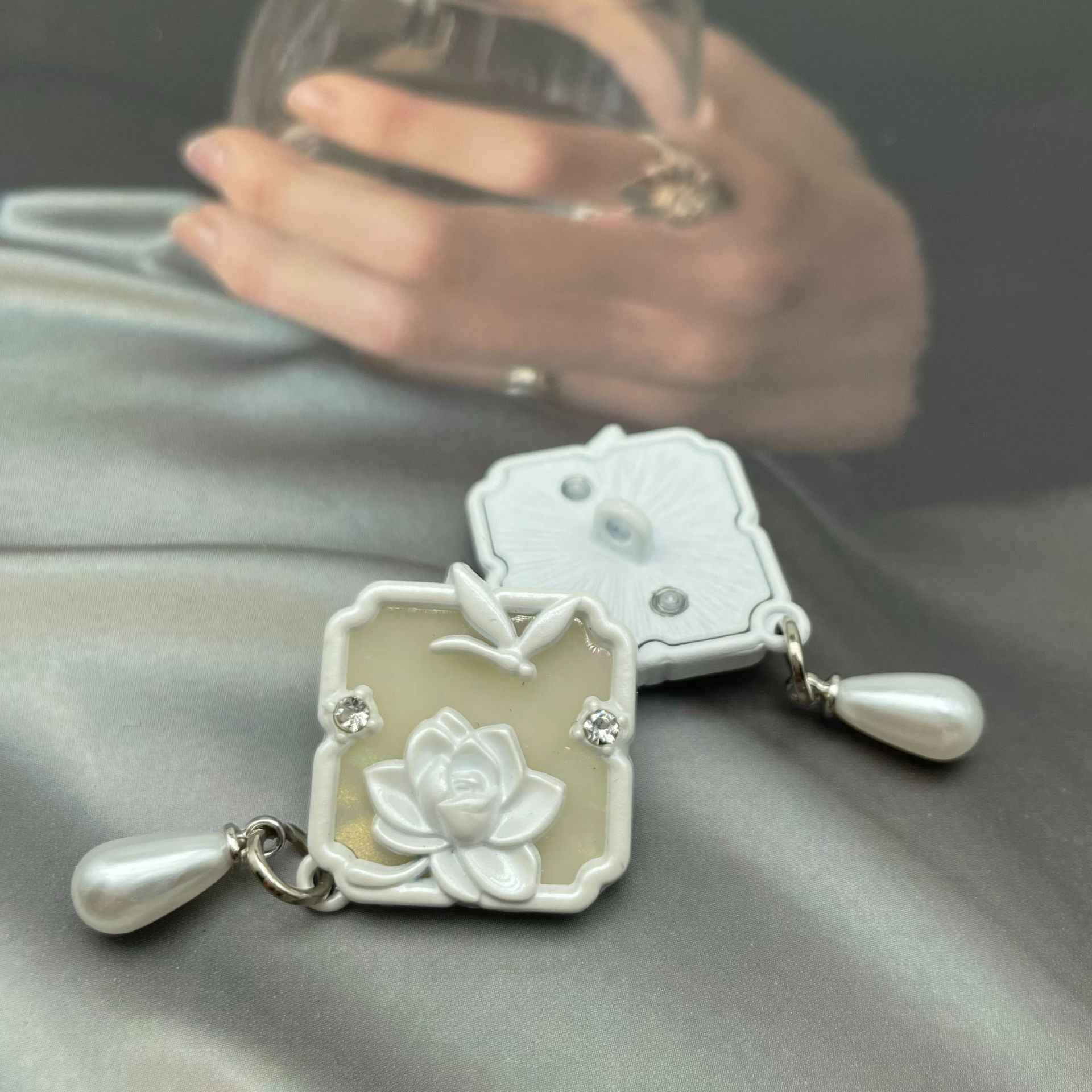 White 1-inch metal sew-on button with lotus design, dragonfly detail, visible sew-through back