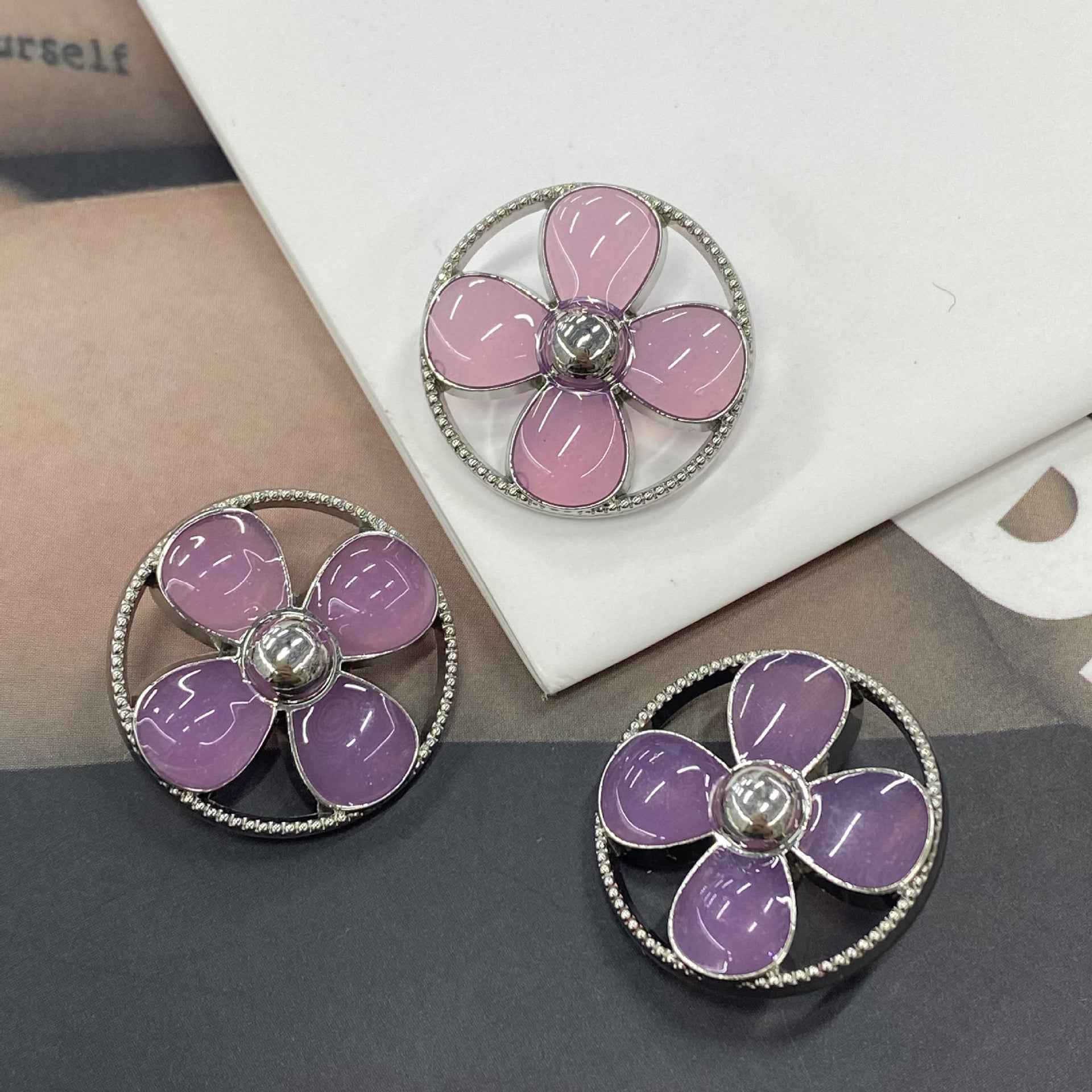 Round clover shank buttons in pink and purple, silver-tone rim with 5-petal flower center