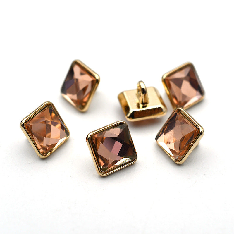 Gold-tone cuff buttons with square glass stones in warm amber and bronze colors