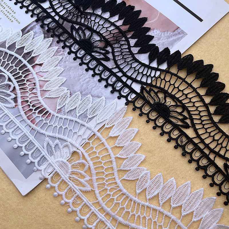 Black lace trim design with curved mesh pattern and scalloped bobble edge