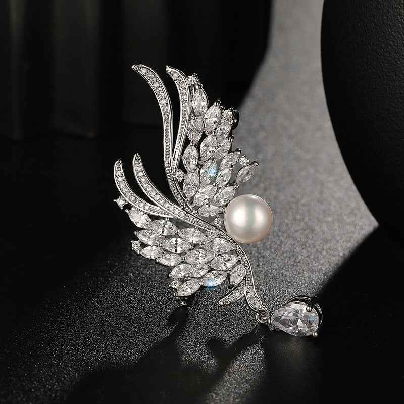 Silver wing metal brooch pin with round pearl and dangling pear-shaped stone