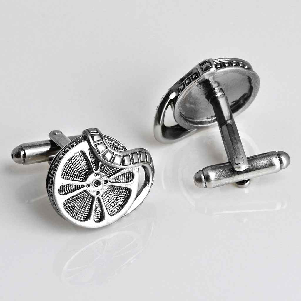 Antique silver cufflinks showing film reel face and swivel backs on posts