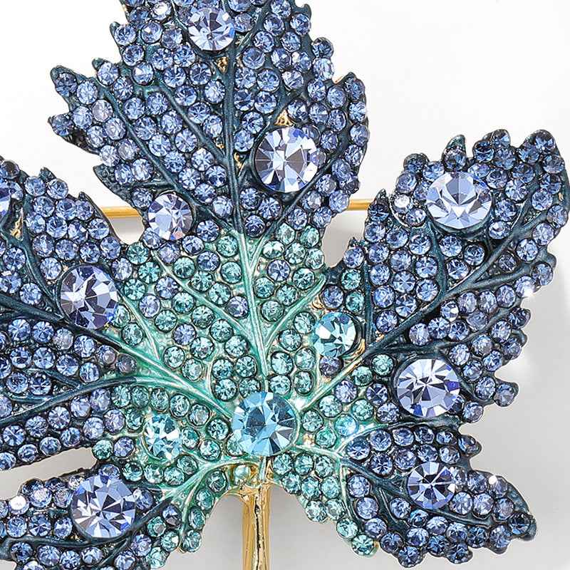 Close-up: blue maple leaf brooch pin with faceted rhinestone details